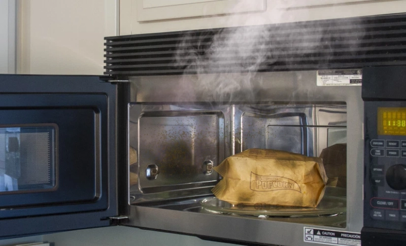 How can you remove smoke residue from the inside of a microwave oven?
